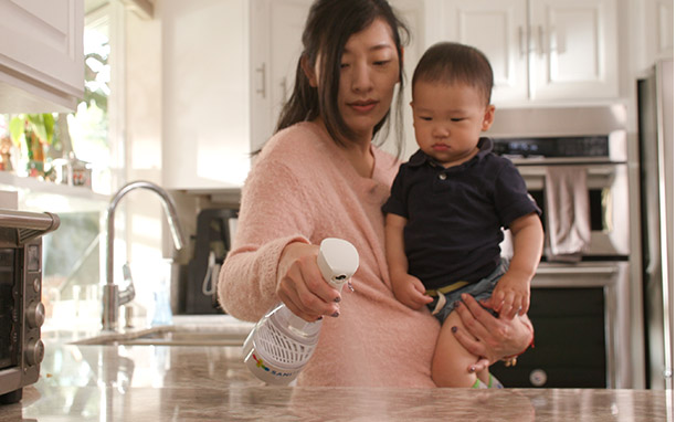 Mom and Baby using SaniTru to clean the countertop